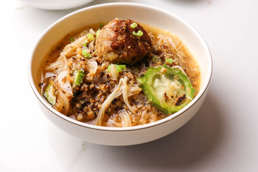 Savory plant-based meatballs in a tomato broth with noodles