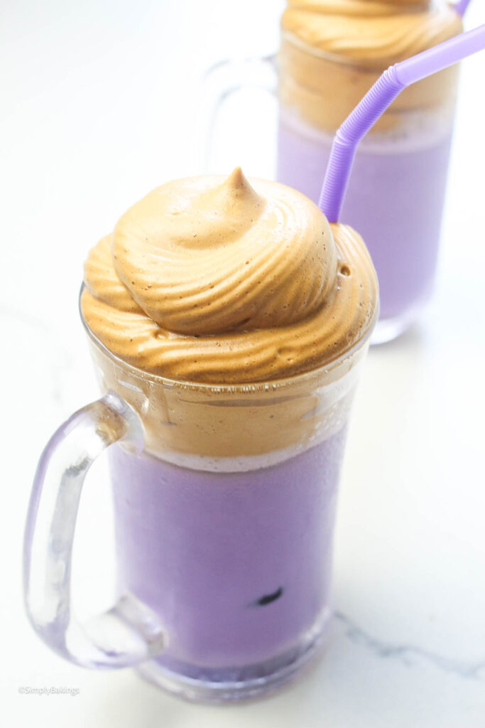 A homemade Ube latte drink with foamy swirl and a purple straw