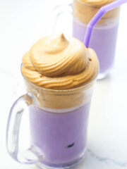 Ube Latte in a clear glass with frothed milk