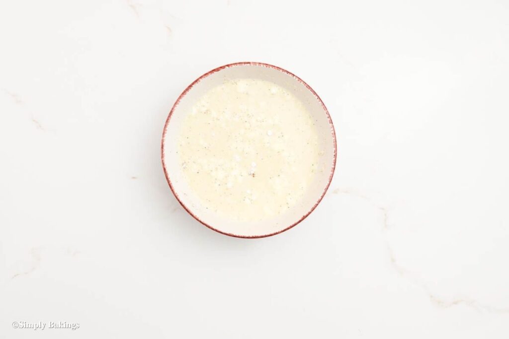A bowl with milk, flour, salt and black pepper