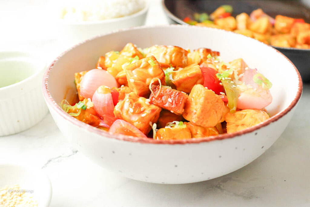 sweet and sour tempeh with pineapple in a bowl of veggies