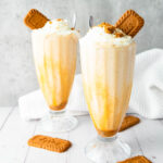 Biscoff Milkshake in tall glasses topped with biscuits