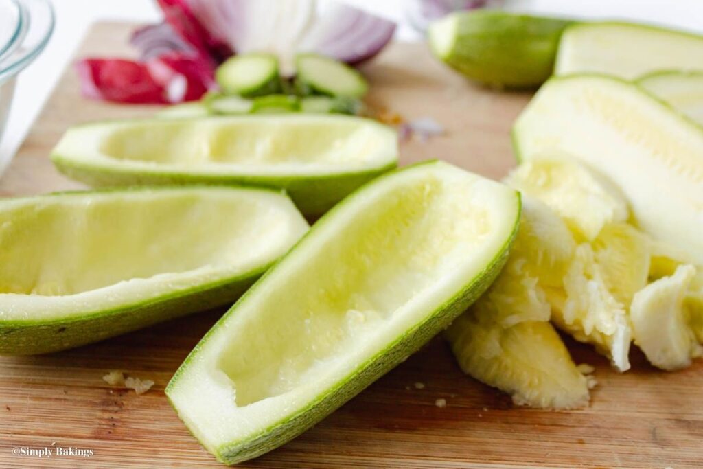 Scooped Zucchini halves on a cutting board