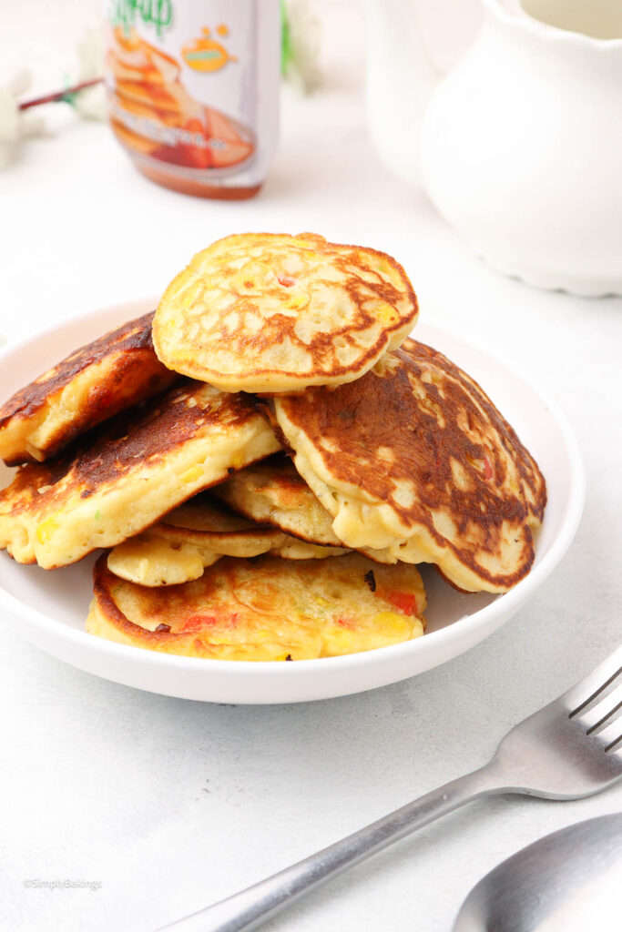 servings of Corn Fritters with Pancake Mix in a white plate next to maple syrup