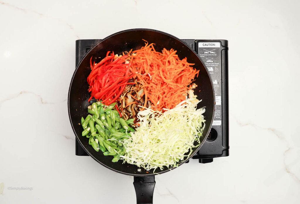 carrot, green beans, bell pepper, and cabbage slices added to the pan