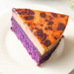 a slice of ube flan served on a white plate
