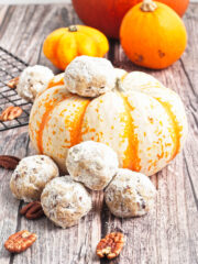 Polvorones Cookies beside a pumpkin on a wooden surface