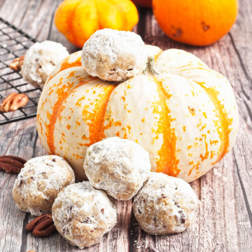 Polvorones Cookies beside a pumpkin on a wooden surface