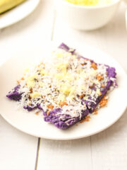 Puto Bumbong topped with coconut, sugar, and cheese