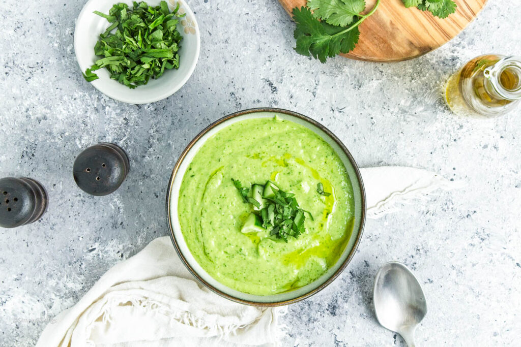 Cucumber Gazpacho surrounded with bowls of ingredients