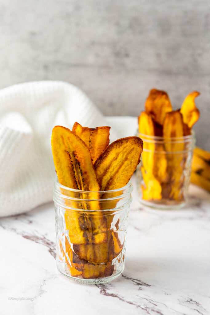 Two cups filled with crispy Plantain Chips