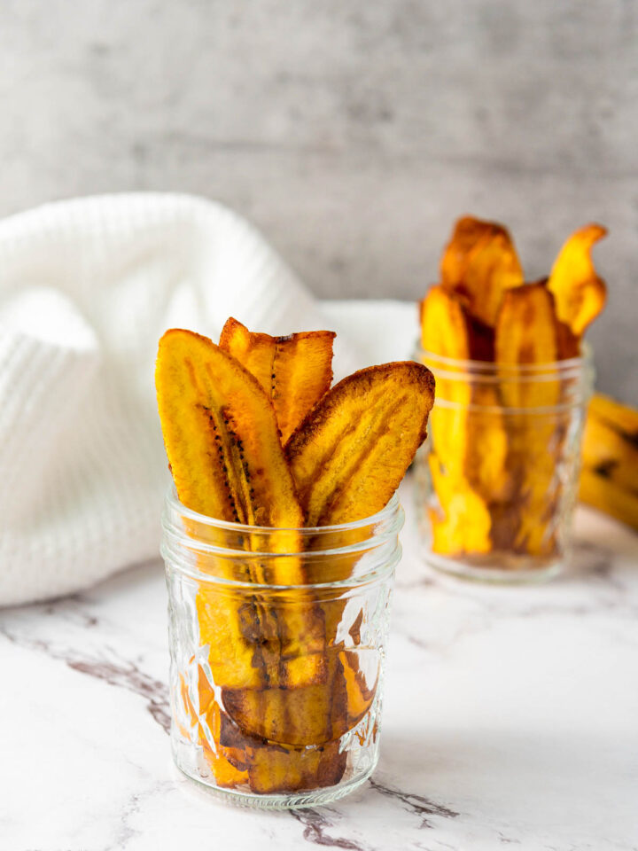 Two cups filled with crispy Plantain Chips