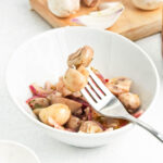 Soy Marinated Mushrooms in a white bowl and scooped up with a fork