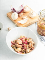 Soy Marinated Mushrooms next to chopping board with some slices of its ingredients