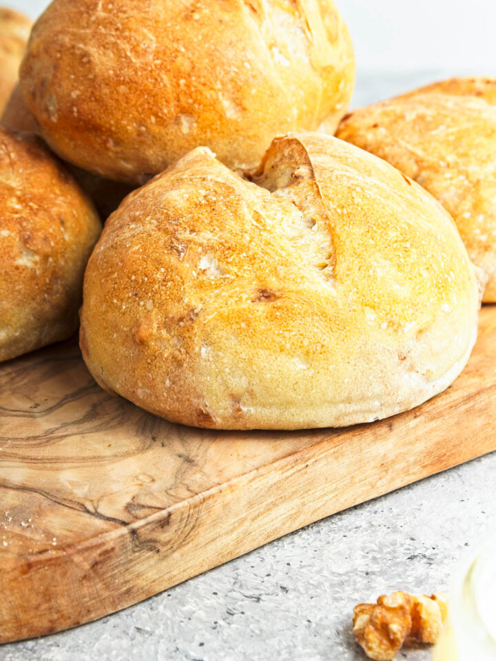 A Crusty Walnut Roll placed with others on a board