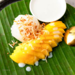 Filipino Mango Sticky Rice on a green leaf-style plate