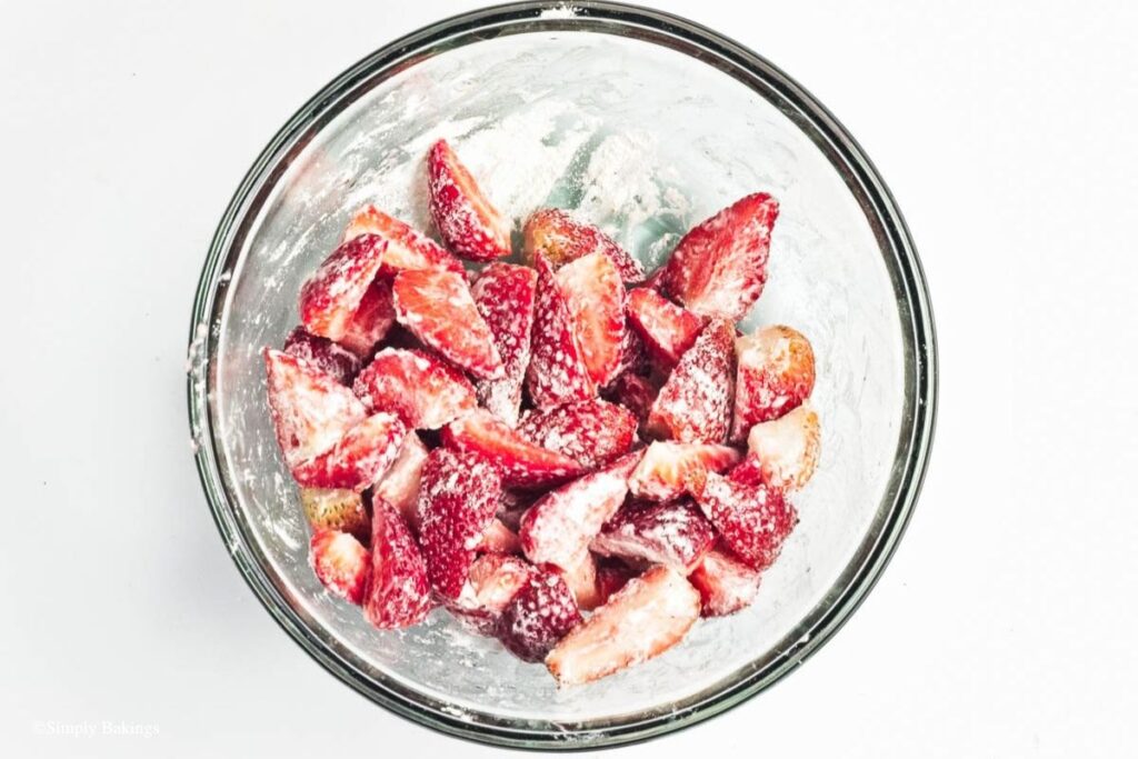 Strawberries in a mixing bowl filled with flour