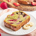 a slice of strawberry matcha bread served on a white plate with 2 banana slices