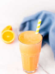 Ginger Orange Juice in a tall glass held