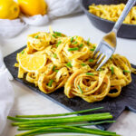 Vegan lemon pasta served on a black rectangular plate at the table