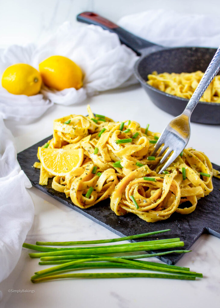 Vegan Lemon Pasta served on a black wooden board with a fork
