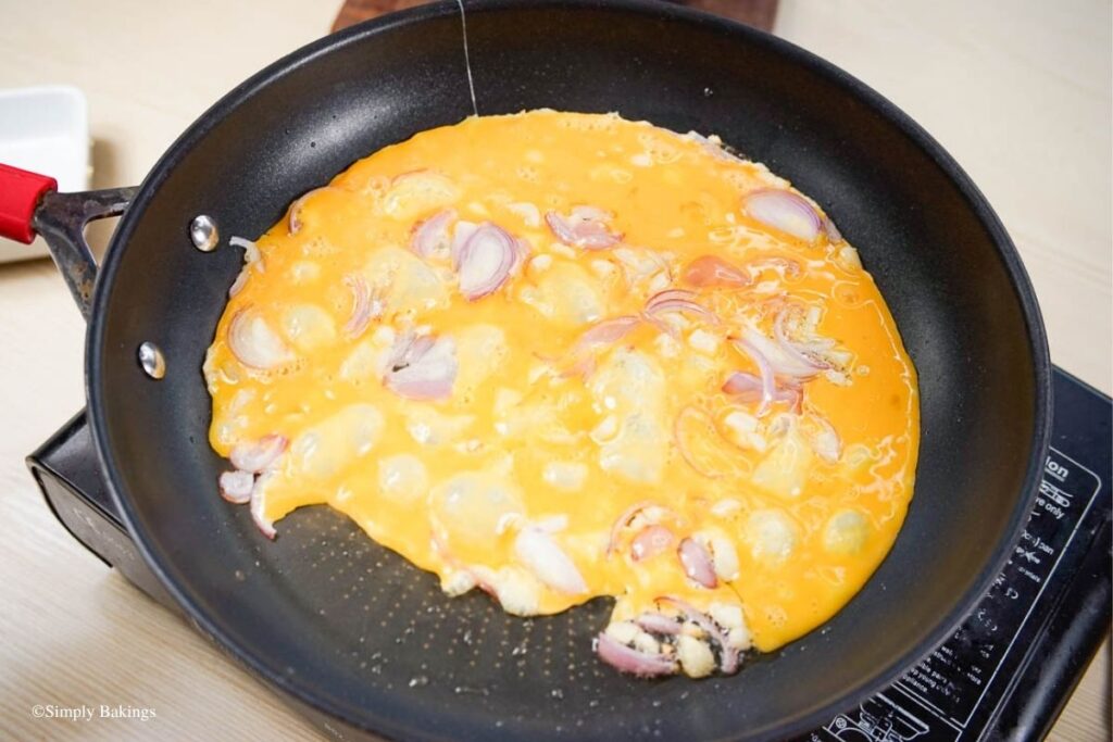 Eggs added into the pan with garlic and onion