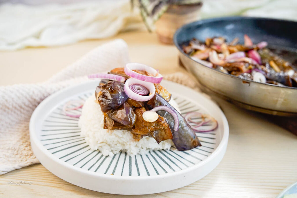 Eggplant bisteak served in a white plate at the table