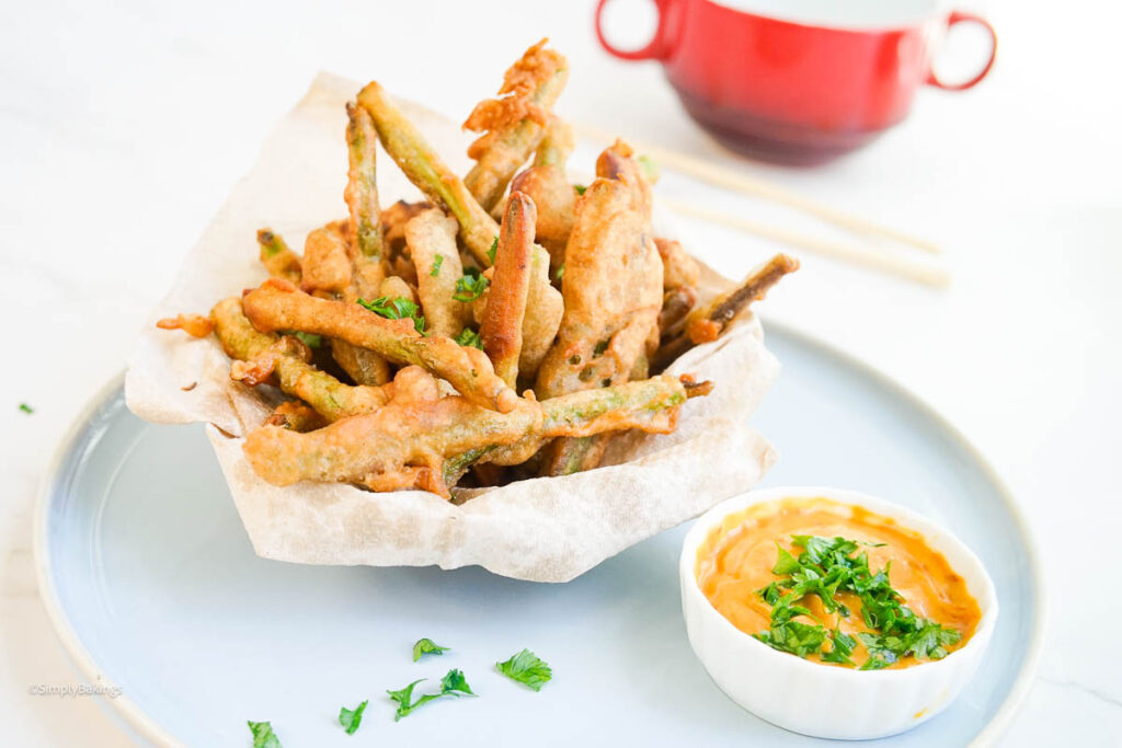 Deep Fried String Beans with sauce next to the bowl