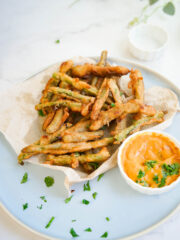 a serving of deep fried string beans next to sauce