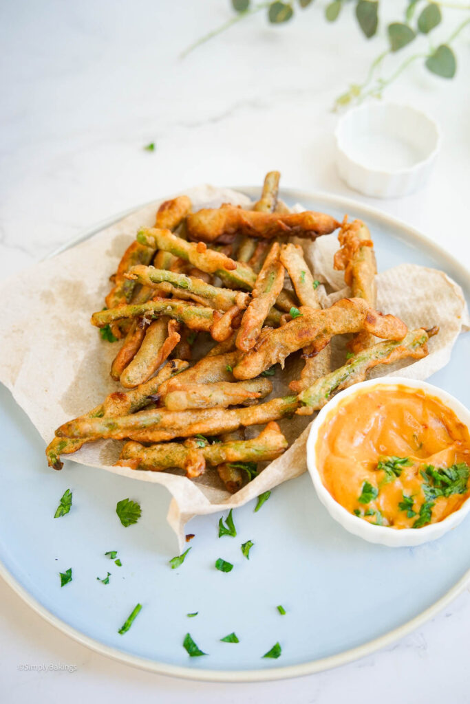 a serving of deep fried string beans next to sauce