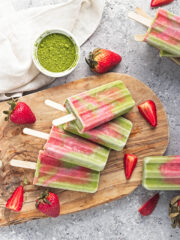 Matcha Strawberry Popsicles on a wooden board