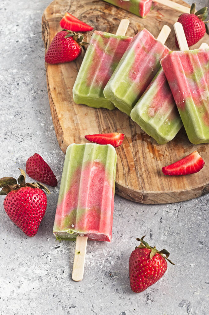 strawberry matcha popsicles on the wooden board with fresh strawberries