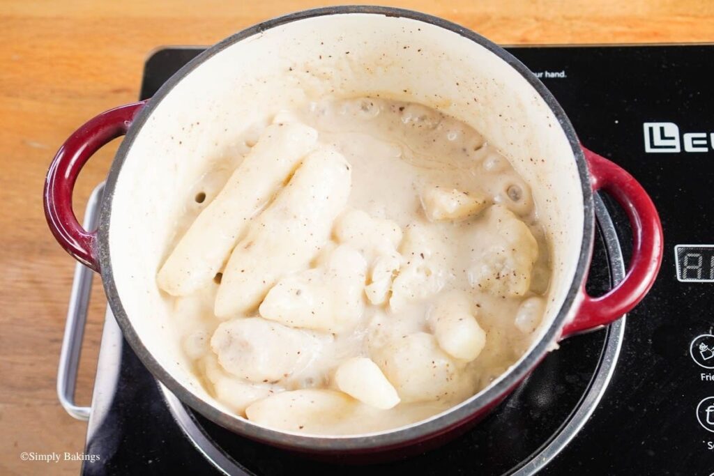A pot of boiling taro with coconut milk over medium heat