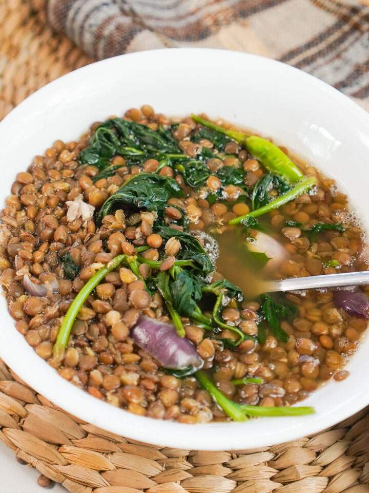 Filipino Lentil Soup served in a white bowl with a spoon