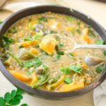 Spoon dipped into Monggo with Kalabasa