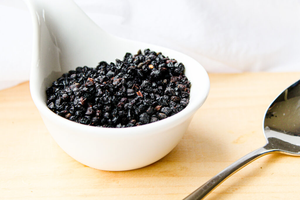 a white bowl with dried elderberries 