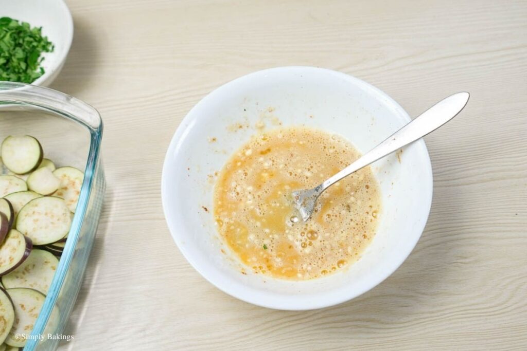 A white bowl filled with beaten egg